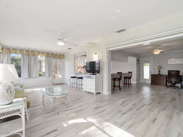 living room with light wood-type flooring and ceiling fan