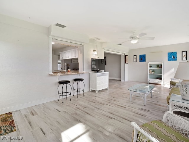 living room with ceiling fan and light hardwood / wood-style floors