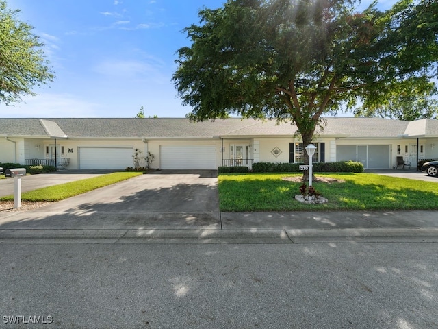 single story home featuring a front yard and a garage