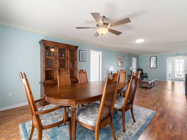 dining area featuring a textured ceiling, crown molding, ceiling fan, and dark wood-type flooring