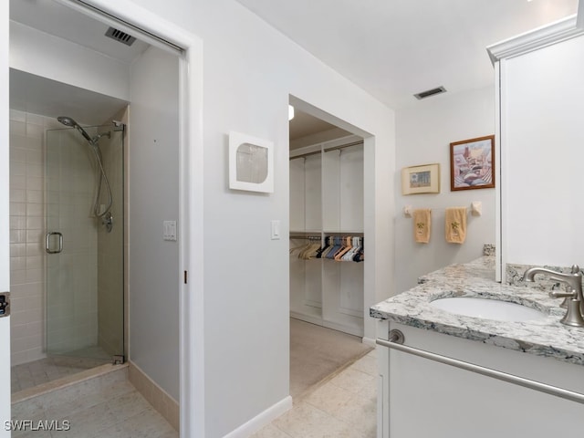 bathroom with tile patterned floors, vanity, and a shower with shower door