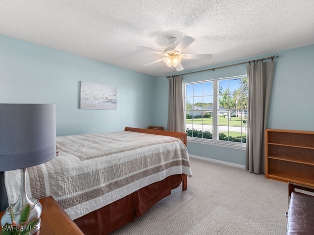 bedroom featuring carpet flooring, ceiling fan, and a textured ceiling