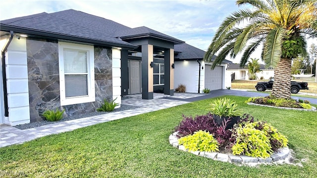 view of front of house featuring a front yard and a garage