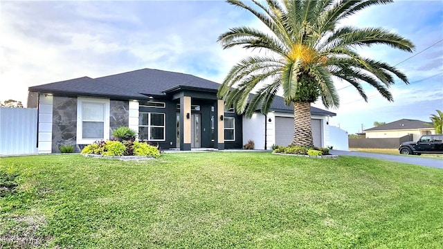 view of front of property featuring a front lawn and a garage