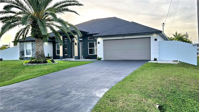 view of front facade featuring a garage and a lawn