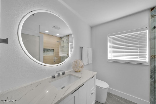 bathroom with vanity, toilet, and a shower with door