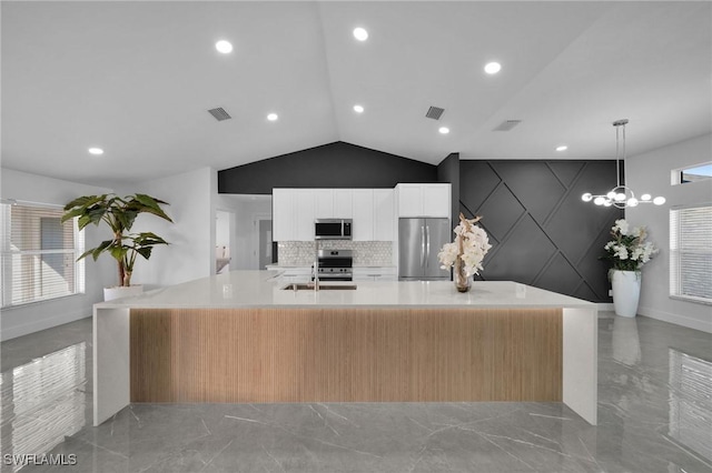 kitchen featuring a large island, pendant lighting, stainless steel appliances, decorative backsplash, and vaulted ceiling