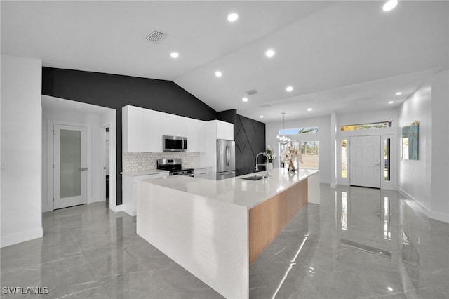 kitchen featuring a spacious island, sink, tasteful backsplash, appliances with stainless steel finishes, and white cabinets