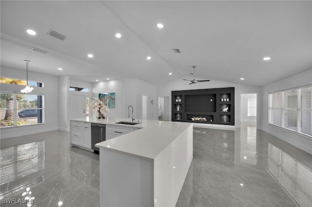 kitchen with vaulted ceiling, pendant lighting, white cabinetry, sink, and ceiling fan