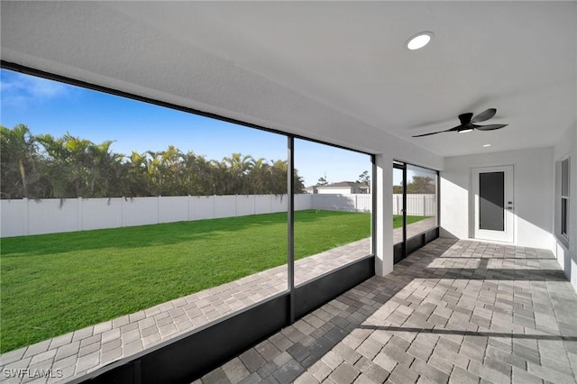 unfurnished sunroom featuring ceiling fan