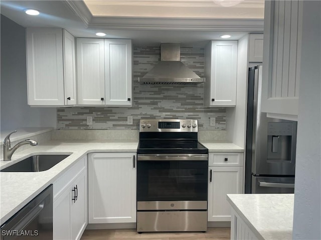 kitchen featuring white cabinets, wall chimney range hood, and stainless steel appliances