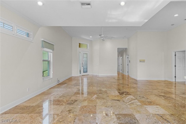 empty room with visible vents, ceiling fan, crown molding, and baseboards