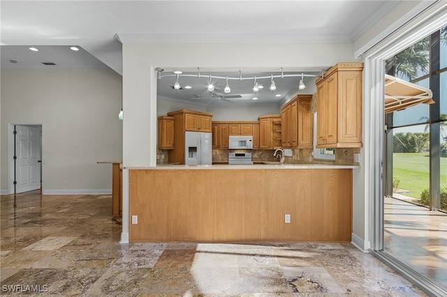 kitchen with sink, kitchen peninsula, crown molding, white appliances, and decorative backsplash