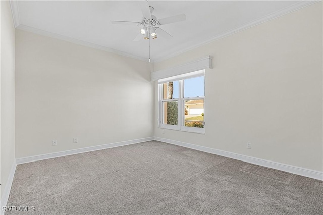 carpeted empty room featuring a ceiling fan, baseboards, and ornamental molding