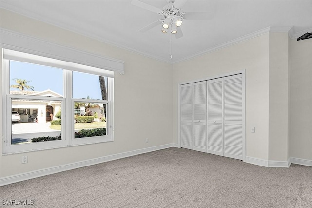 unfurnished bedroom with baseboards, carpet, a closet, and ornamental molding