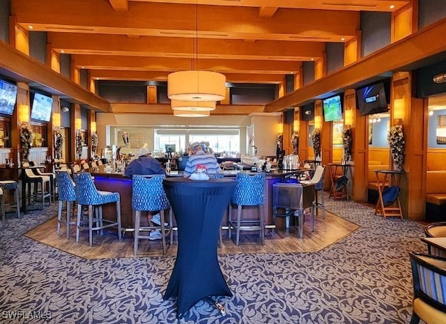 bar featuring beamed ceiling, decorative light fixtures, and dark carpet