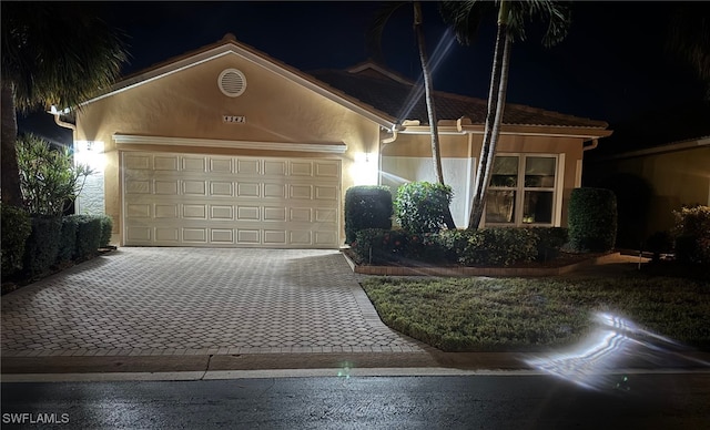 view of front of home featuring a garage, decorative driveway, and stucco siding