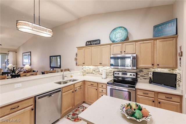 kitchen with lofted ceiling, sink, decorative light fixtures, and stainless steel appliances