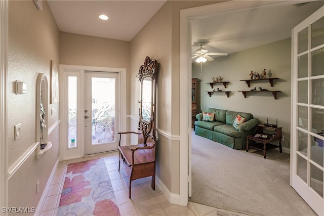 carpeted foyer featuring ceiling fan