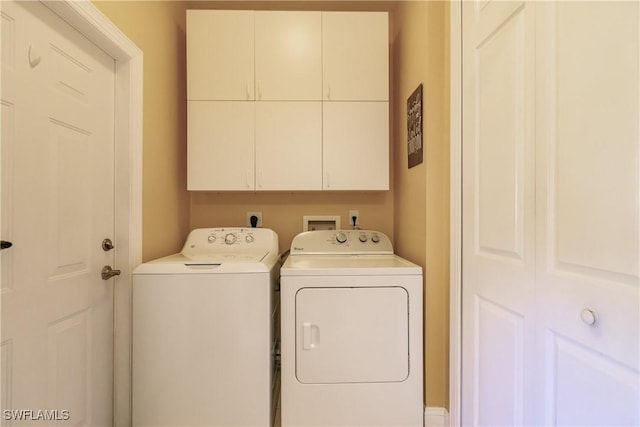 laundry area with cabinets and washing machine and dryer