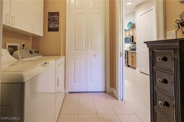 laundry area with cabinets, light tile patterned floors, and washer and dryer