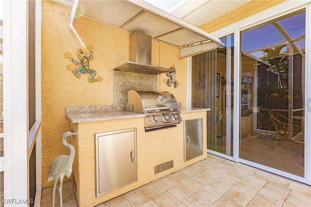 patio terrace at dusk with a grill and exterior kitchen