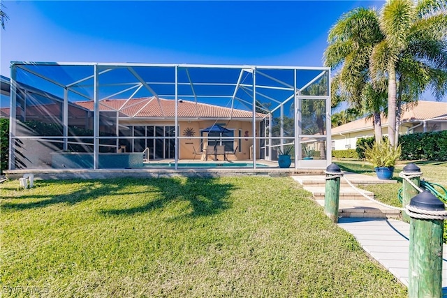 rear view of house with a lanai, a yard, a swimming pool, and a patio area