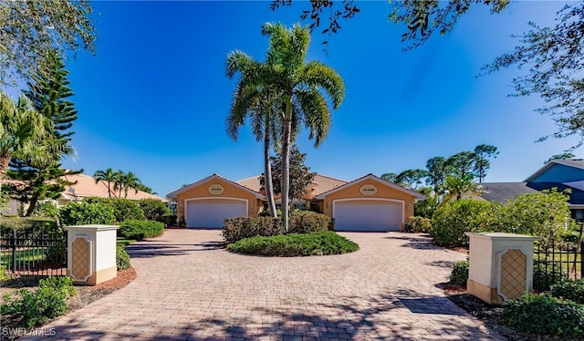 15192 Riverbend Blvd, North Fort Myers, FL 33917 - view of property hidden behind natural elements featuring stucco siding, decorative driveway, and an attached garage