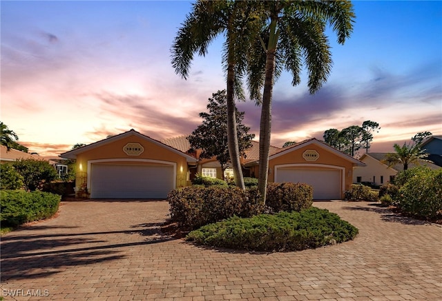 15192 Riverbend Blvd, North Fort Myers, FL 33917 - ranch-style home with stucco siding, decorative driveway, and a garage