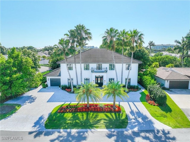 55 E Burning Tree Dr, Naples, FL 34105 - mediterranean / spanish-style house featuring decorative driveway, stucco siding, and a balcony