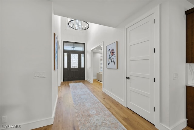 foyer with light hardwood / wood-style floors and an inviting chandelier