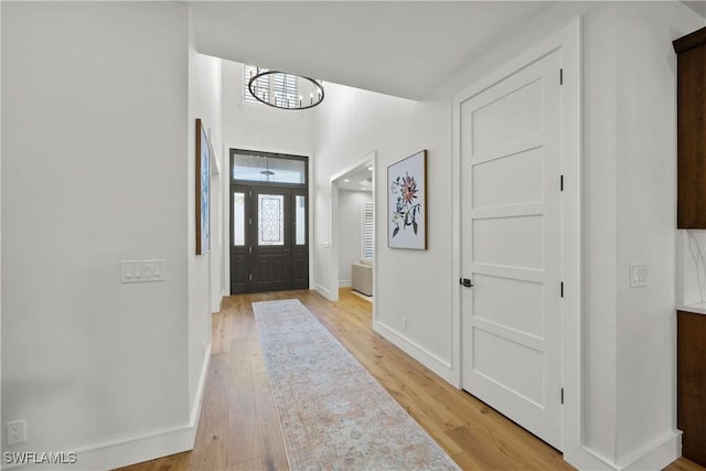 55 E Burning Tree Dr, Naples, FL 34105 - foyer with a chandelier, light wood finished floors, and baseboards