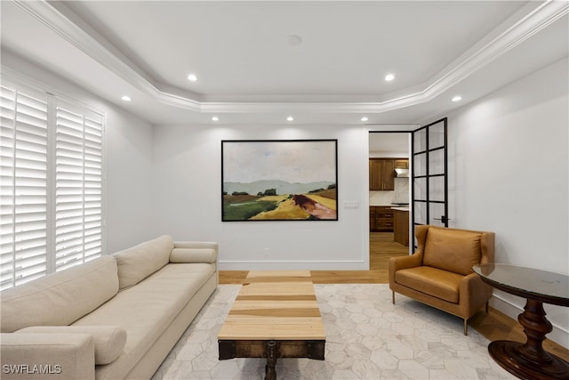 cinema featuring light hardwood / wood-style floors, crown molding, and a tray ceiling