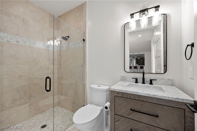 bathroom featuring vanity, toilet, and an enclosed shower