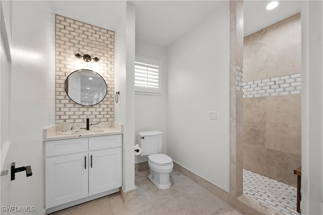 bathroom featuring tile patterned flooring, toilet, tiled shower, decorative backsplash, and vanity