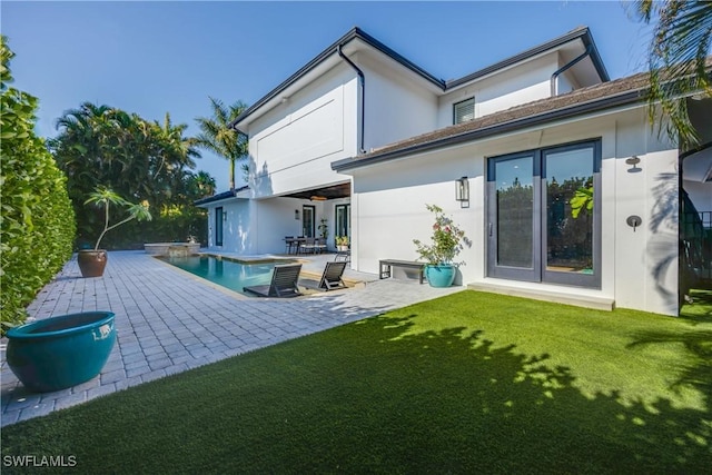 55 E Burning Tree Dr, Naples, FL 34105 - rear view of property with stucco siding, a yard, a patio, and an outdoor pool