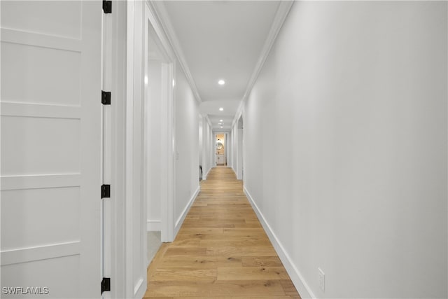 hallway featuring light hardwood / wood-style floors and crown molding