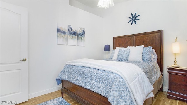 bedroom with baseboards and wood finished floors