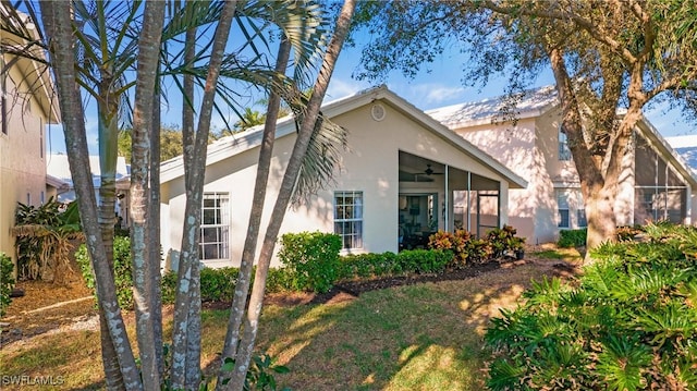 view of front facade with ceiling fan and a sunroom