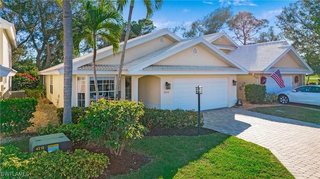 view of front of home with a garage, decorative driveway, and stucco siding