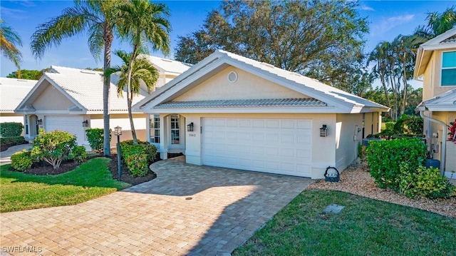 view of front of home featuring a garage, decorative driveway, and stucco siding