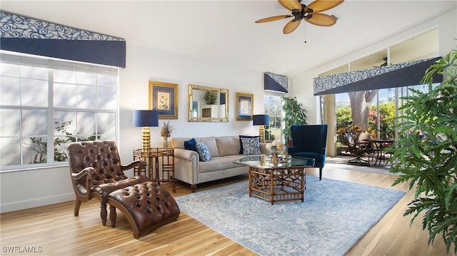 living room featuring ceiling fan, wood-type flooring, and lofted ceiling