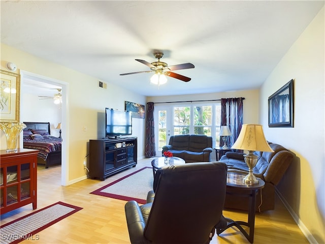 living room with ceiling fan and light hardwood / wood-style floors