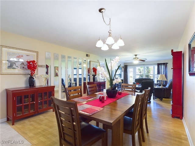 dining room featuring ceiling fan with notable chandelier and light wood-type flooring