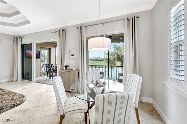 dining space with ornamental molding, a water view, and light tile patterned floors