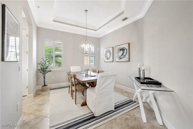 tiled dining room with a chandelier, crown molding, and a raised ceiling