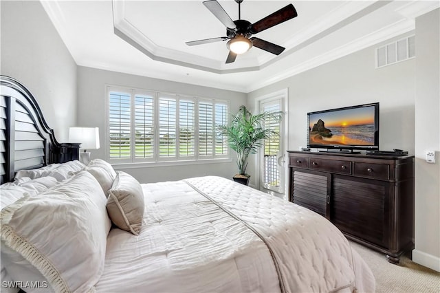 carpeted bedroom featuring access to exterior, crown molding, a raised ceiling, and ceiling fan