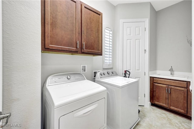 washroom with cabinets, sink, and washer and dryer