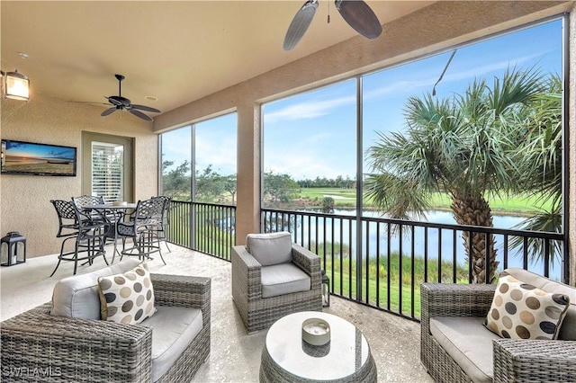 sunroom / solarium featuring a water view and ceiling fan