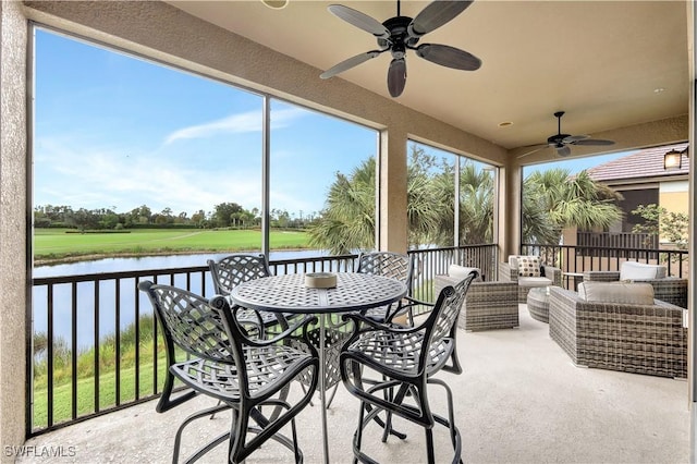 sunroom featuring a water view